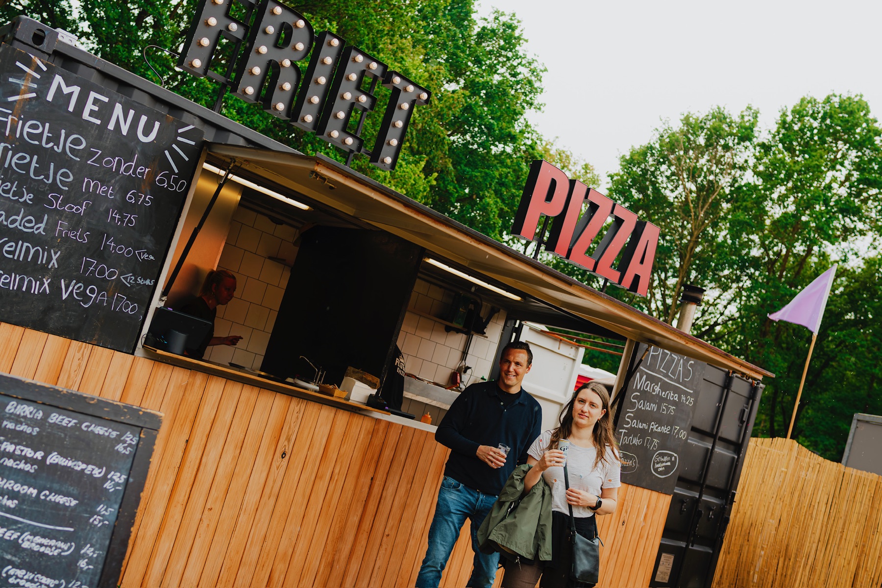 Mobiele pizza foodtruck en houtoven op een festivalterrein