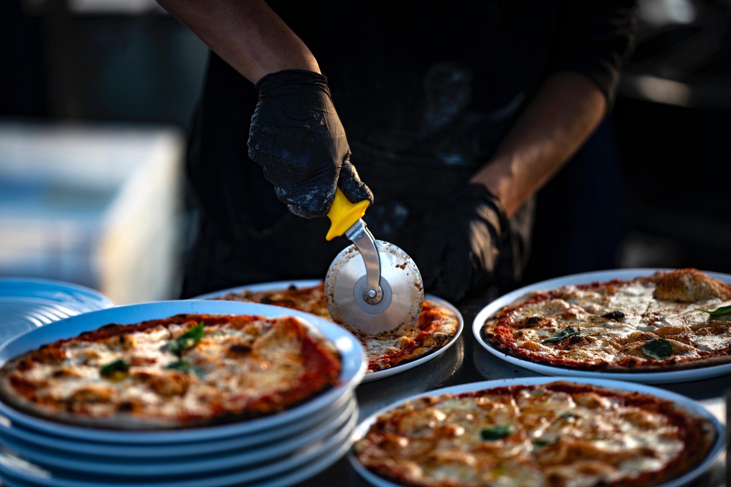 Verse pizza wordt tijdens een feest aangesneden en geserveerd