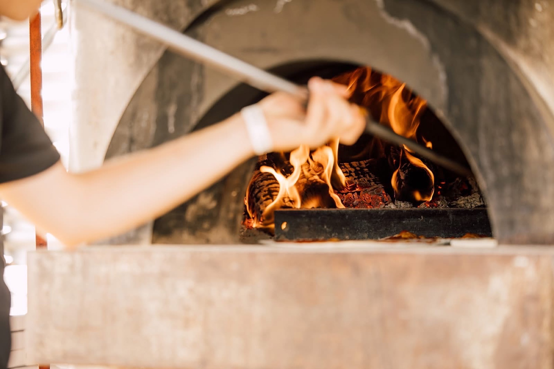 Pizza wordt vers gebakken in een houtgestookte steenoven